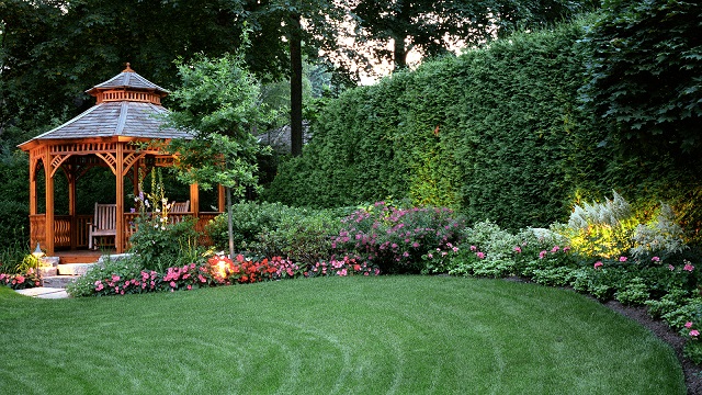 Landscaped backyard with a timber gazebo, garden lighting and flowering garden beds