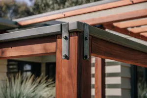 Close-up detail of a timber pergola post joint with steel bracket hardware