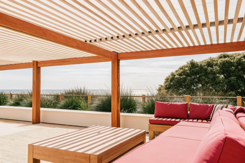 Timber slatted pergola shading an outdoor lounge setting with ocean views